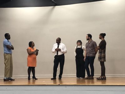 Father Pinder speaks to his kids in the play, Pinder's Kids.